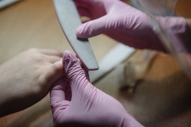 Manikürcü bir tırnak dosyası ile çivi kolları.