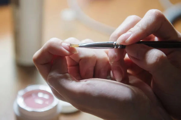 Manicure aplica verniz na unha de perto — Fotografia de Stock