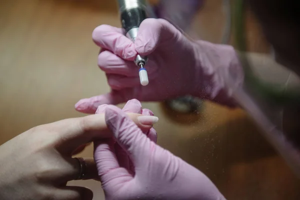 La manicura hace la manicura de hardware de cerca. El tratamiento de las uñas con la ayuda del hardware manicura —  Fotos de Stock