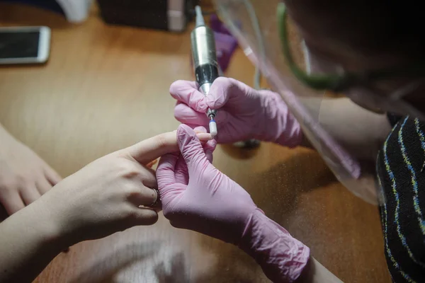 La manicura hace la manicura de hardware de cerca. El tratamiento de las uñas con la ayuda del hardware manicura —  Fotos de Stock