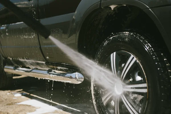 A man washes a car with a high pressure washer — Stock Photo, Image