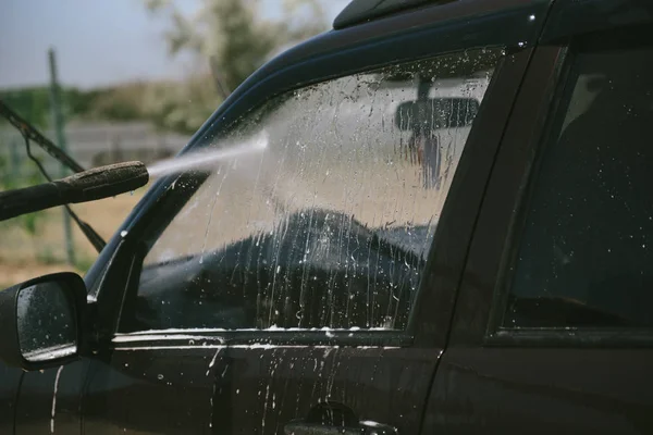 A man washes a car with a high pressure washer — Stock Photo, Image