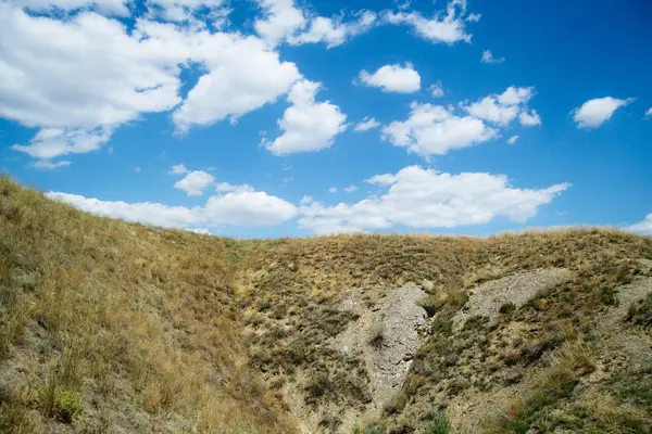 Uzak tepeler. Tepelik bozkır. Kıvrımlı tepeler. Mavi gökyüzü ve çimenler. Güzel düz. — Stok fotoğraf