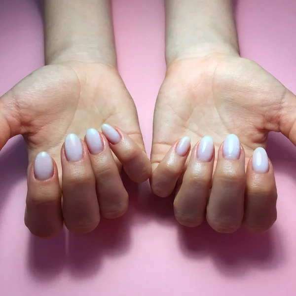 Manucure de différentes couleurs sur les ongles. Manucure féminine sur la main sur fond rose — Photo