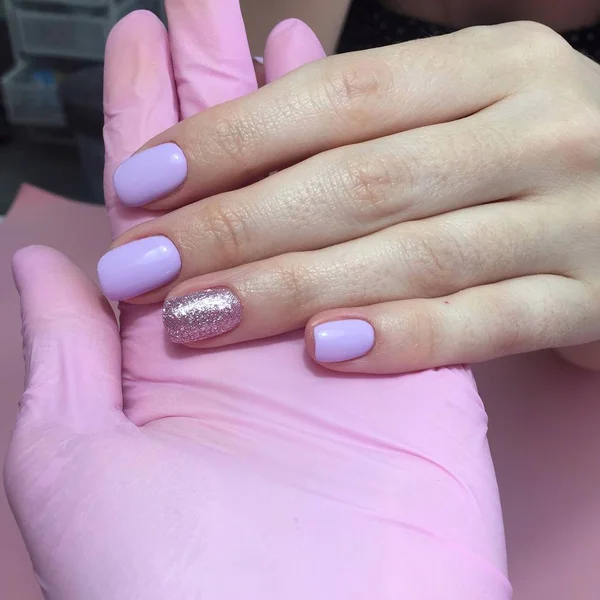 Manicure of different colors on nails. Female manicure on the hand on pink background — Stock Photo, Image