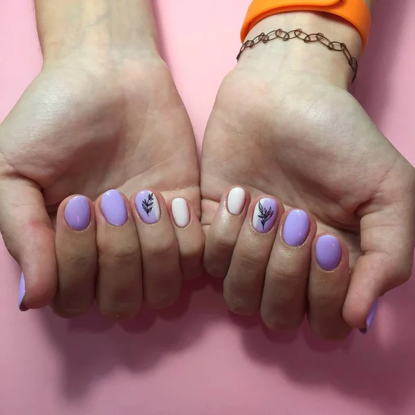 Manicure różnych kolorach na paznokciach. Kobiecy manicure na dłoni na różowym tle — Zdjęcie stockowe