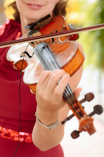 Beautiful woman in a dress plays the violin close-up. — Stock Photo, Image