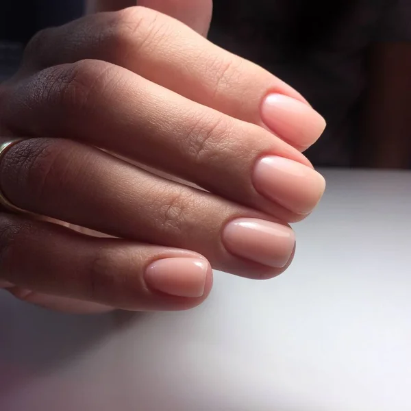 Női kéz stílusos rózsaszín manikűr fehér háttér — Stock Fotó