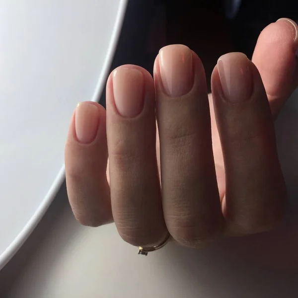 Manos femeninas con elegante manicura rosa sobre fondo blanco — Foto de Stock