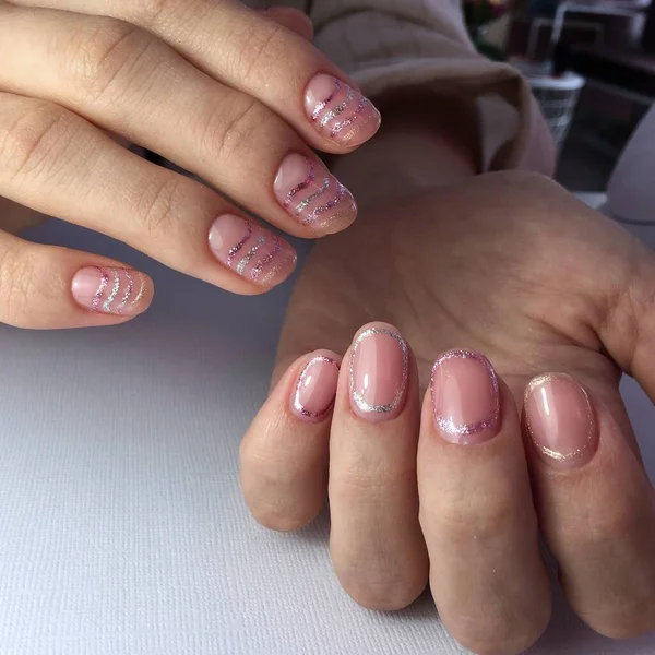 Mãos femininas com manicure rosa elegante no fundo branco — Fotografia de Stock