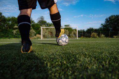 Futbol sahasında topu olan futbolcuya yakın durun. Futbol sahasında topu olan erkek futbolcu. Futbol sporu kavramı.