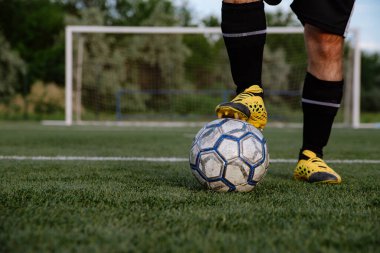 Futbol sahasında topu olan futbolcuya yakın durun. Futbol sahasında topu olan erkek futbolcu. Futbol sporu kavramı.