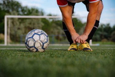 Futbol sahasında topu olan futbolcuya yakın durun. Futbol sahasında topu olan erkek futbolcu. Futbol sporu kavramı.
