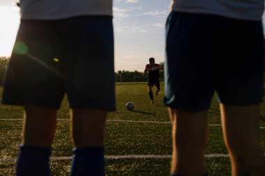 Futbolcu topa vuruyor. Futbolcu serbest vuruşu yapıyor. Futbolcu futbol sahasında topa vuruyor. Futbol sporu kavramı.