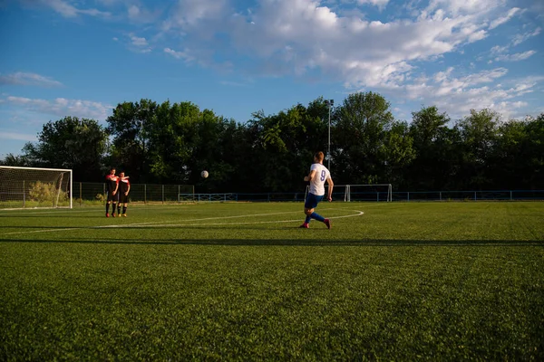 サッカー選手はボールを蹴ります サッカー選手はフリーキックを取ります サッカー選手はサッカー場でボールを蹴ります — ストック写真