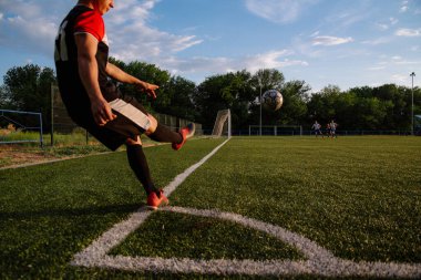 Futbolcu topa vuruyor. Futbolcu köşeyi dönüyor. Futbolcu futbol sahasında topa vuruyor. Futbol sporu kavramı.