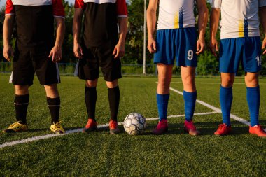 Farklı takımlardan futbolcular maçtan önce futbol sahasında dururlar. Futbol sporu kavramı.