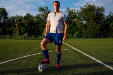 Futbol sahasında topu olan futbolcuya yakın durun. Futbol sahasında topu olan erkek futbolcu. Futbol sporu kavramı.