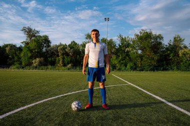 Futbol sahasında topu olan futbolcuya yakın durun. Futbol sahasında topu olan erkek futbolcu. Futbol sporu kavramı.