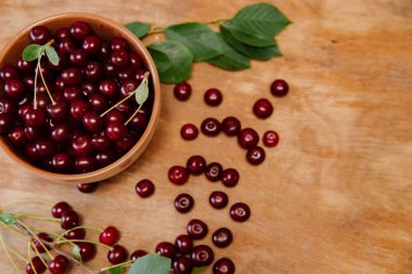 Ahşap arka planda taze kiraz. Taze kirazlar. Tatlı kirazlar. Ahşap arka planda bir tabakta tatlı kırmızı kirazlar.