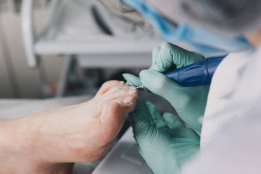 Hırdavat pedikür. Elektrikli makine kullanan profesyonel donanım pedikürü. Maske ve eldiven yapımında uzman. Güzellik salonunda pedikür süreci.