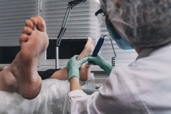 Young woman getting professional pedicure in beauty salon.Peeling feet pedicure procedure in a beauty salon.