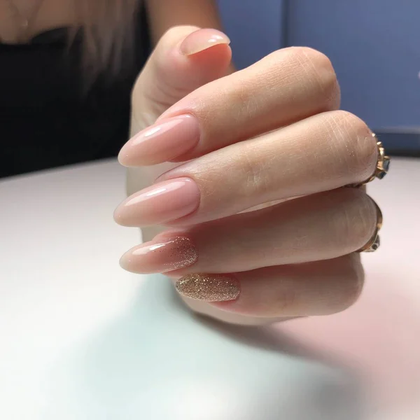 Hands of a woman with pink manicure on nails.Manicure beauty salon concept. Empty place for text or logo.