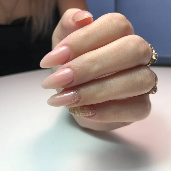 Hands of a woman with pink manicure on nails.Manicure beauty salon concept. Empty place for text or logo.