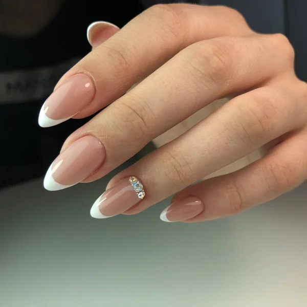 French manicure on the nails.Manicure gel nail polish. Spa and Manicure concept. Female hands with french manicure.