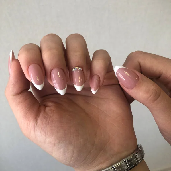 French manicure on the nails.Manicure gel nail polish. Spa and Manicure concept. Female hands with french manicure.