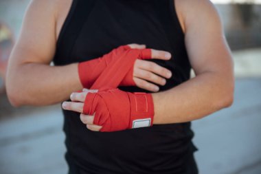Kırmızı boks bandajlı boksörün eli. Boksör, antrenmandan önce bandajı eline bağlar.