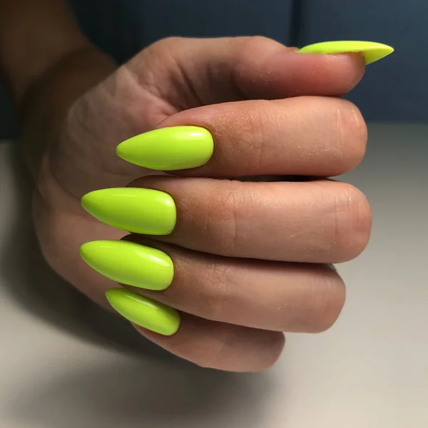 Green manicure. Hands of a woman with green manicure on nails.Manicure beauty salon concept. Empty place for text or logo.