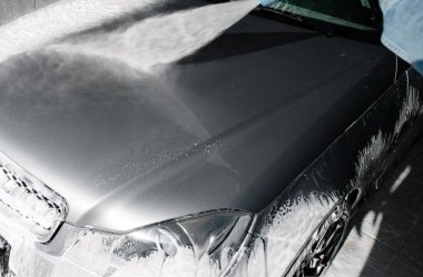 Araba yıkama. Araba Temizleme Suyu Kullanımı Yüksek Basınçlı Su. Erkek işçi arabayı yüksek basınçlı yıkama makinesiyle yıkıyor.