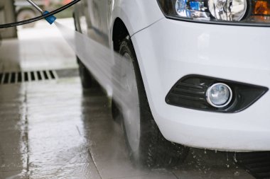 Araba yıkama. Araba Temizleme Suyu Kullanımı Yüksek Basınçlı Su. Erkek işçi arabayı yüksek basınçlı yıkama makinesiyle yıkıyor.