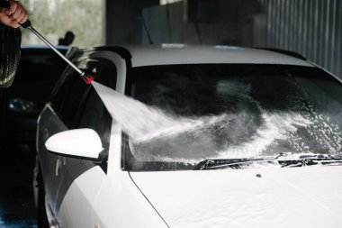 Araba yıkama. Araba Temizleme Suyu Kullanımı Yüksek Basınçlı Su. Erkek işçi arabayı yüksek basınçlı yıkama makinesiyle yıkıyor.