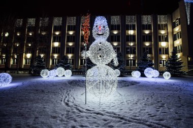 Güzel, ışıl ışıl kardan adamlar. Beyaz elektrik çelenklerinden.