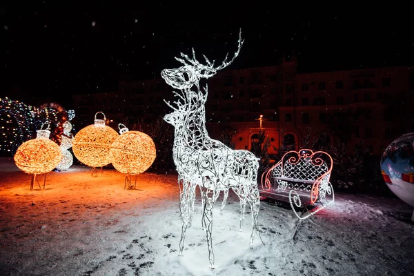 Christmas decorations on the street. White Christmas deer. Garlands outside decorate the street. Holiday lights in the form of a deer on the street on Christmas Eve.