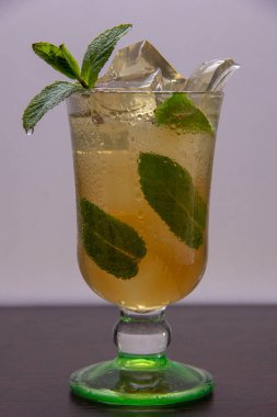 Hafif ferahlatıcı bir içecek, buz ve nane yaprakları, cam aşağı su akışı damla ile bir cam kadeh, bir nane dalı serin bir yaz kokteyli ile dekore edilmiştir.