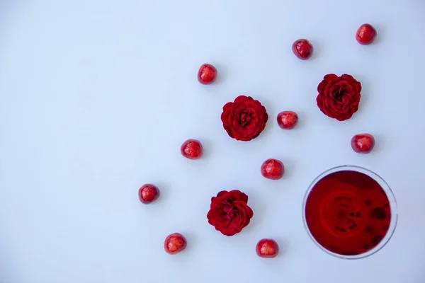 Ένα Ποτήρι Ένα Κόκκινο Ποτό Γλυκά Κεράσια Ευωδιαστά Τριαντάφυλλα Λευκό — Φωτογραφία Αρχείου