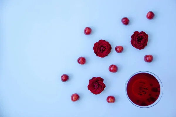 Ένα Ποτήρι Κόκκινο Ποτό Ώριμα Κεράσια Ευωδιαστά Τριαντάφυλλα Λευκό Φόντο — Φωτογραφία Αρχείου