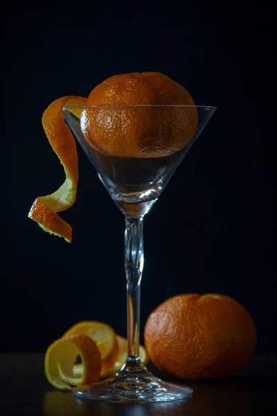 Reife Mandarine Liegt Einem Martini Glas Auf Schwarzem Hintergrund Orangefarbene — Stockfoto