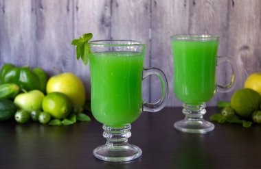 İki bardak karışık vejetaryen içeceği ve ahşap arka planda malzemeler. Taze organik meyve püresi. Detoks ve diyet gıda konsepti. Yatay görünüm, alanı kopyala.