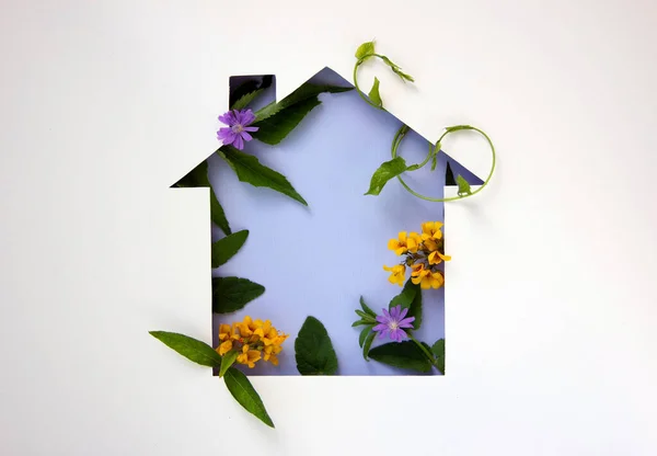 Coronavirus, COVID-19 protection logo with nature background. Shape cut out of paper in the form of a house with natural plants and flowers inside. Ecology concept. Care of nature. Copy space.