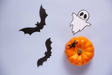 Cadılar Bayramı süslemeleri, balkabağı, hayalet ve yarasalar mavi arka planda. Tatil konsepti. Düz konum, üst görünüm, kopyalama alanı. 