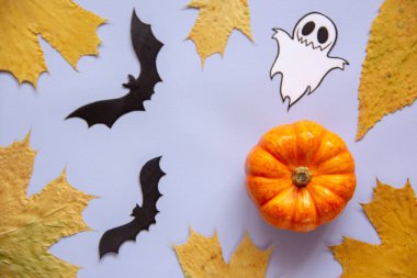 Cadılar Bayramı süslemeleri, balkabağı, hayalet, yarasalar ve düşen sonbahar yaprakları mavi arka planda. Tatil konsepti. Düz konum, üst görünüm, kopyalama alanı. 