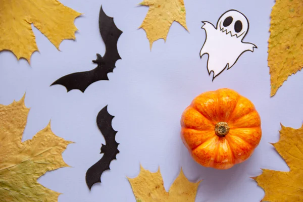 Cadılar Bayramı süslemeleri, balkabağı, hayalet, yarasalar ve düşen sonbahar yaprakları mavi arka planda. Tatil konsepti. Düz konum, üst görünüm, kopyalama alanı. 