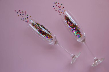 Parlak yıldızlar şeklinde konfetili gözlüklerin yaratıcı düzeni. Tatil konsepti. Tebrik kartı. Üst görünüm, düz görünüm, kopyalama alanı.