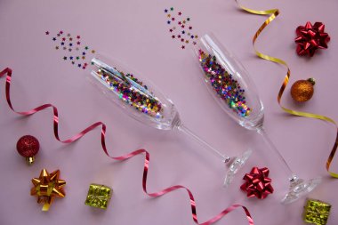 Pembe arka planda gözlüklü, parıltılı ve noel toplu yaratıcı düz kompozisyon. Kış tatili, Noel zamanı konsepti. Üst görünüm, alanı kopyala.