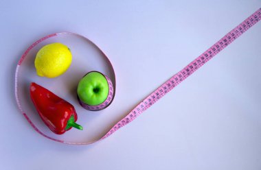 Elma, biber, limon ve pembe arka planda şeritli yaratıcı düz kompozisyon. Aralıklı, keto, detoks ve ince diyetler. Sağlıklı beslenme konsepti. Boşluğu kopyala.
