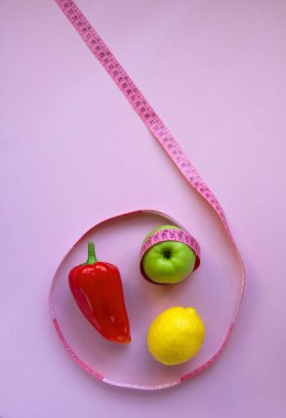Elma, biber, limon ve pembe arka planda şeritli yaratıcı düz kompozisyon. Aralıklı, keto, detoks ve ince diyetler. Sağlıklı beslenme konsepti. Boşluğu kopyala.